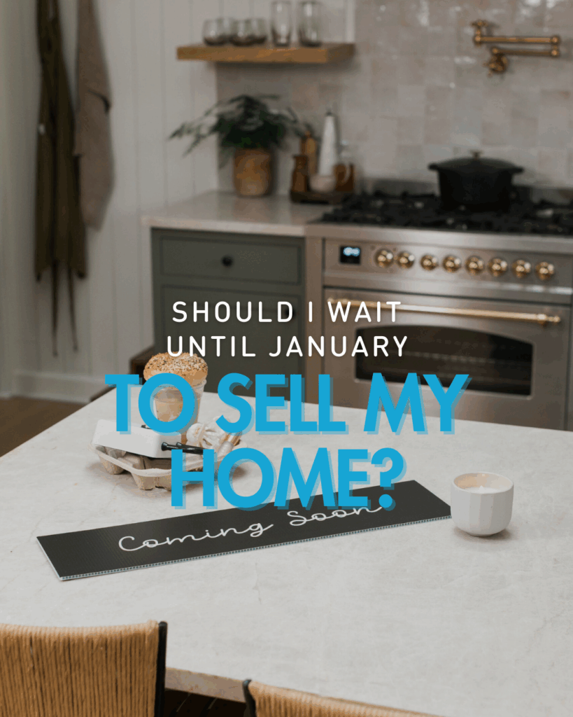Modern kitchen with a marble island, wicker chairs, and a “Coming Soon” real estate sign on the counter, with text overlay reading “Should I wait until January to sell my home?”